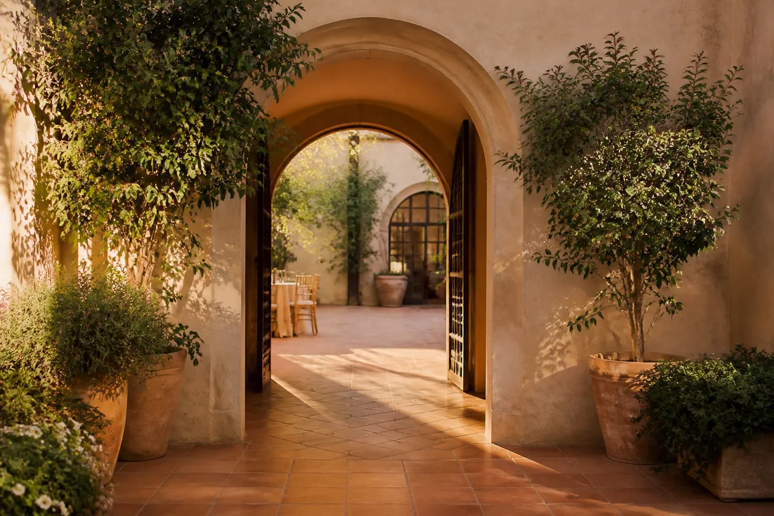 Sunlit courtyard venue framed by a terracotta archway